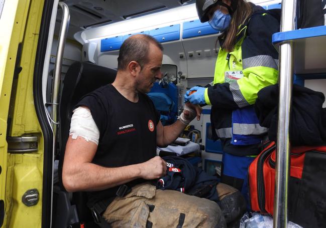 Los servicios de emergencia atienden al bombero herido en el incendio.