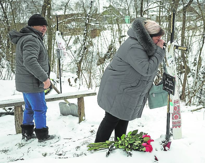 Una mujer visita la tumba de su hermana en Bucha.