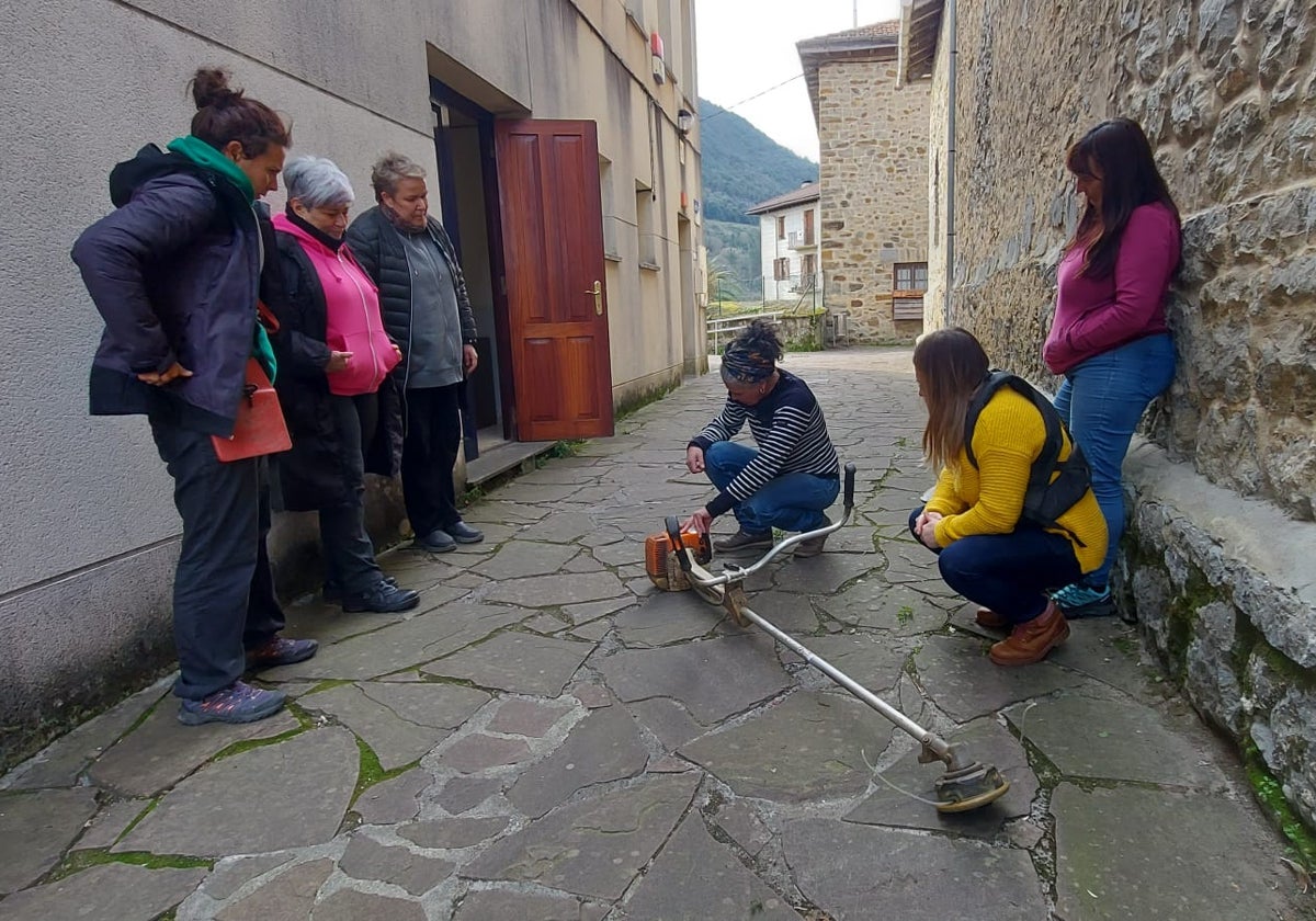 Alumnas atienden las explicaciones sobre el manejo de maquinaría agrícola en el curso de Busturia.