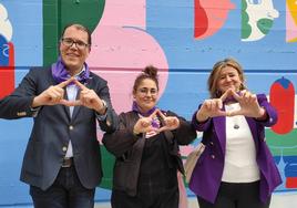El alcalde de Ortuella, Saulo Nebreda, la autora del mural, Janire Orduna, y la diputada Teresa Laespada hacen el gesto feminista con las dedos formando un triángulo.