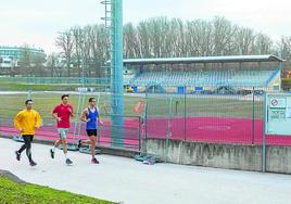 Atletas se ejercitan fuera de la pista, vallada por obras.