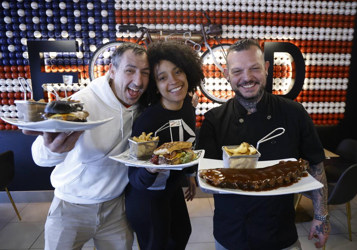 Johny Sanchotena, Ramón Francho y Saile Mederos posan con varios platos de su restaurante.