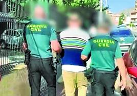 Agentes de la Guardia Civil custodian a uno de los detenidos.