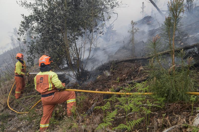 Un equipo refrigera el terreno ya devastado por las llamas