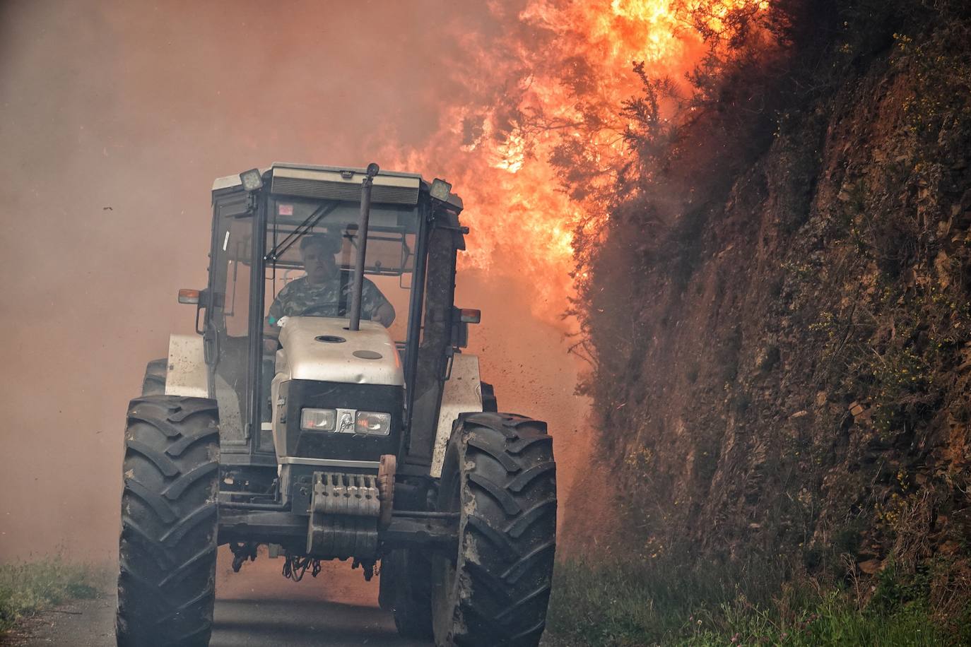 Un vecino huye de las llamas en su tractor.