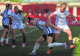 Carla Armengol trata de quitarle el balón a la capitana del Sevilla, Amanda Sampedro.