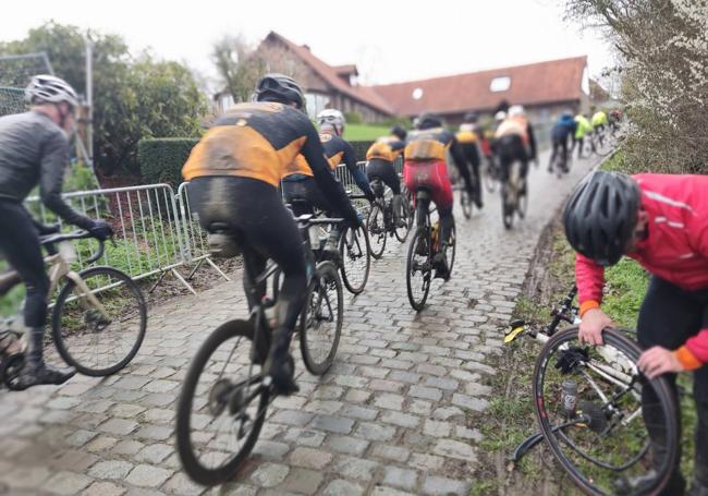 Un ciclista arregla un pinchazo en el muro de Patenberg