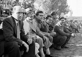 Lecube, tercero por la izquierda (con sombrero), en el banquillo del Camp d'Esports.