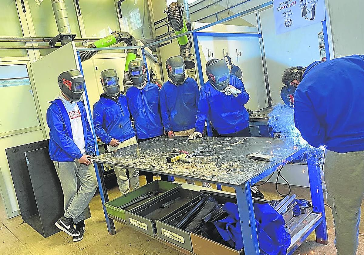 Alumnos del FP de soldadura observan el trabajo de un compañero dentro del programa COVIDA.