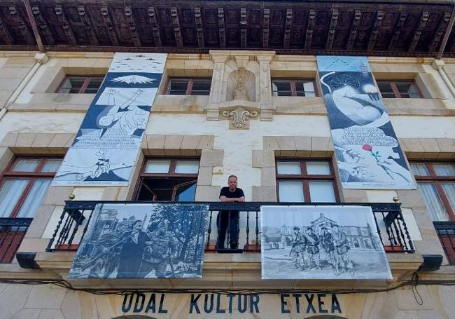 Aitor Arana posa entre dos de lasde su exposición que cuelgan de la fachada de la Casa de Cultura de Gernika.