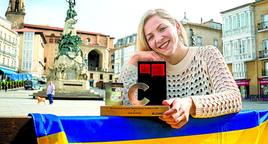 Julia Butenko sostiene el trofeo de Alavesa del mes en la plaza de la Virgen Blanca.