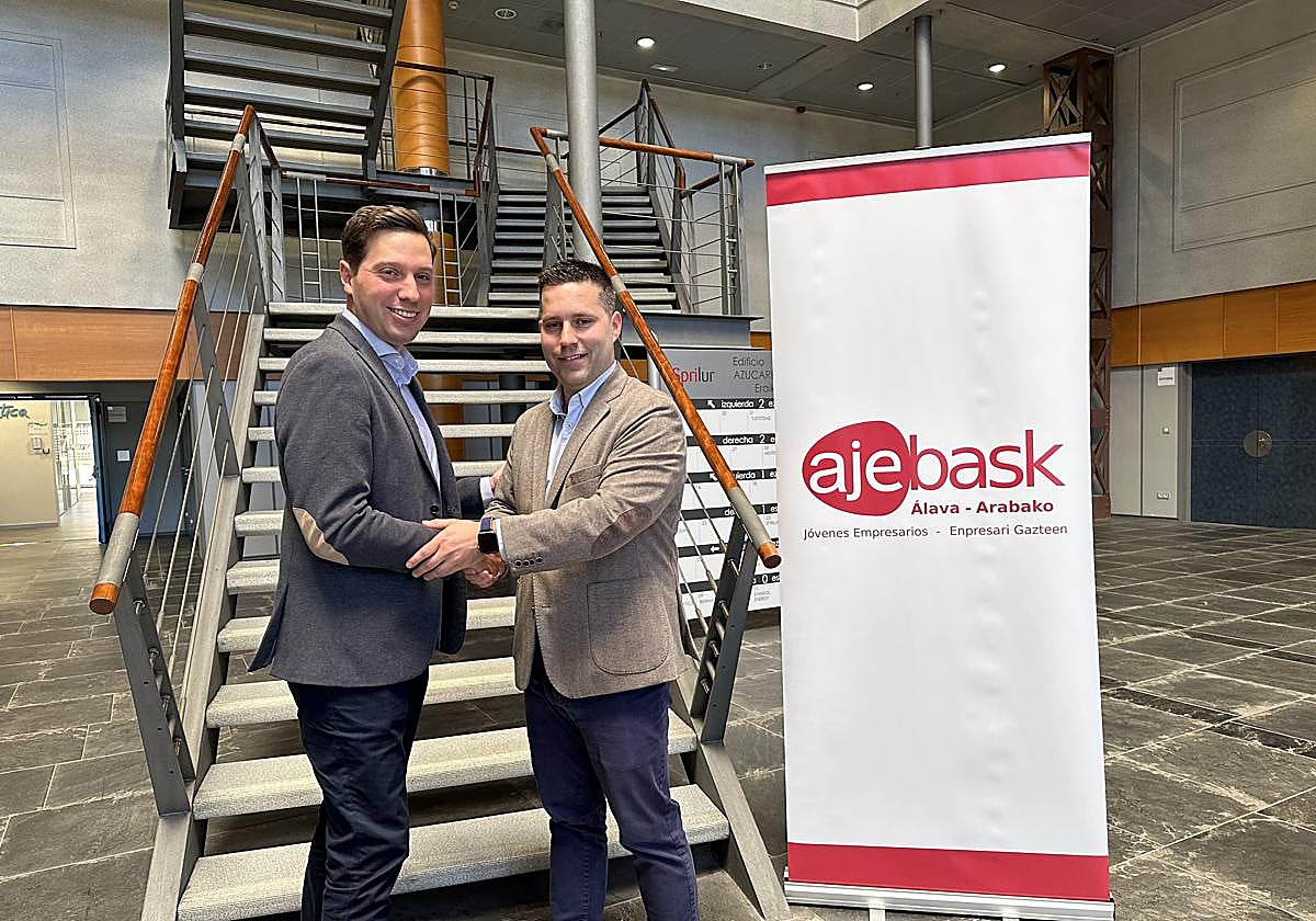 Iñigo Juez (izqda) y Juan Carlos García se estrechan la mano tras el cambio de poderes en Ajebask