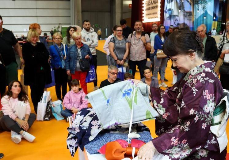 Una mujer muestra la moda japonesa ante un público atento.