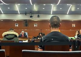 La víctima declara mientras el acusado, de negro, escucha en el banquillo.