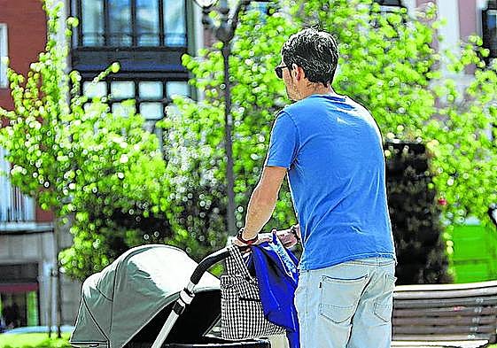 Un hombre pasea ayer por Bilbao con un cochecito de bebé.