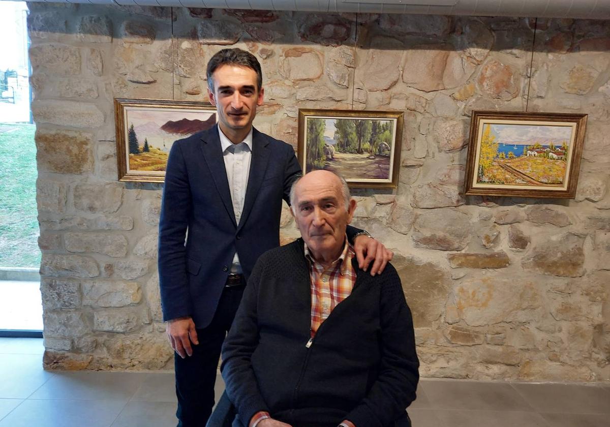 Txema Bengoa posa junto a su hijo Carlos frente a su última colección de cuadros pintados al óleo.