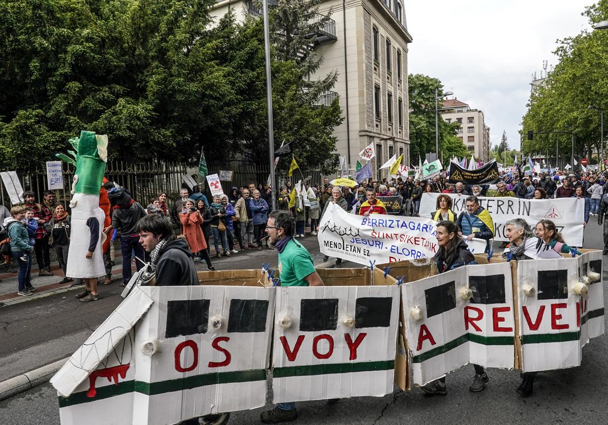 Manifestantes contra los proyectos renovables e industriales marchan en Vitoria simulando un vagón del TAV.