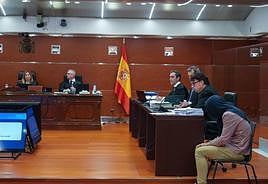 El ya condenado a la prisión permanente revisable, a la derecha de la imagen, se cubre la cabeza con un jersey durante el juicio.