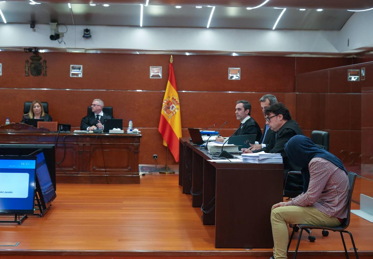 El ya condenado a la prisión permanente revisable, a la derecha de la imagen, se cubre la cabeza con un jersey durante el juicio.