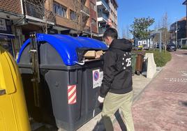 Un joven recicla cartón en un contenedor de Berango.