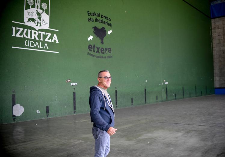 Imagen principal - Juan Mari en el frontón, uno de los orgullos de Izurtza. La carretera que atraviesa el pueblo y el panel de anuncios con la cartelería electoral.