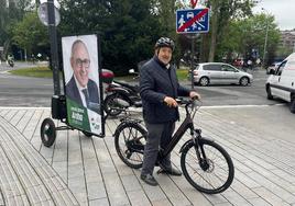 José Antonio Suso, presidente del PNV alavés, con un altavoz y el cartel de Ramiro González en Lovaina.