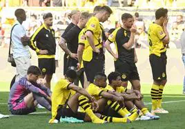 Jugadores del Dortmund lloran sobre el césped tras perder la liga en el último suspiro.