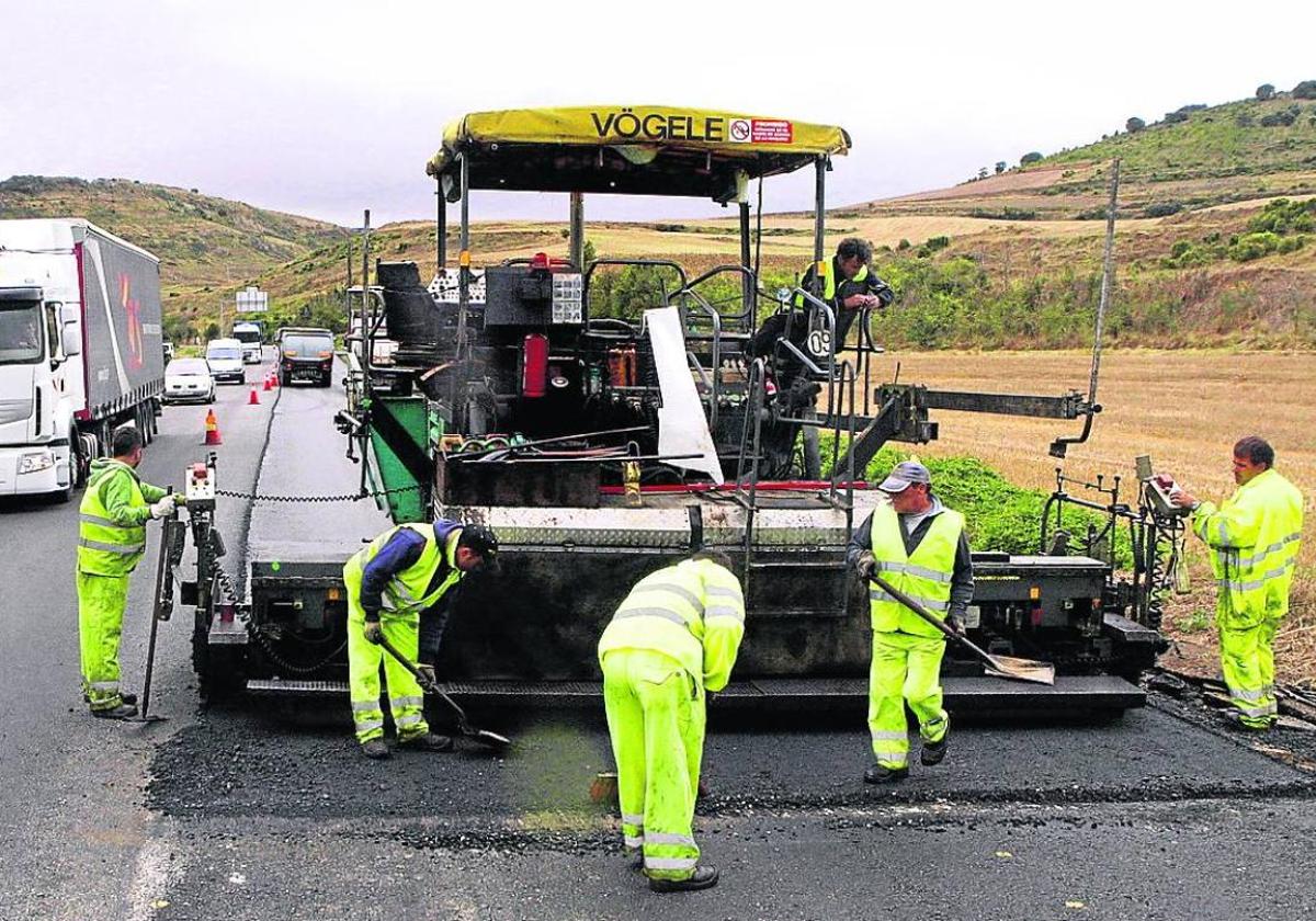 Varios trabajadores participan en el asfaltado de una carretera