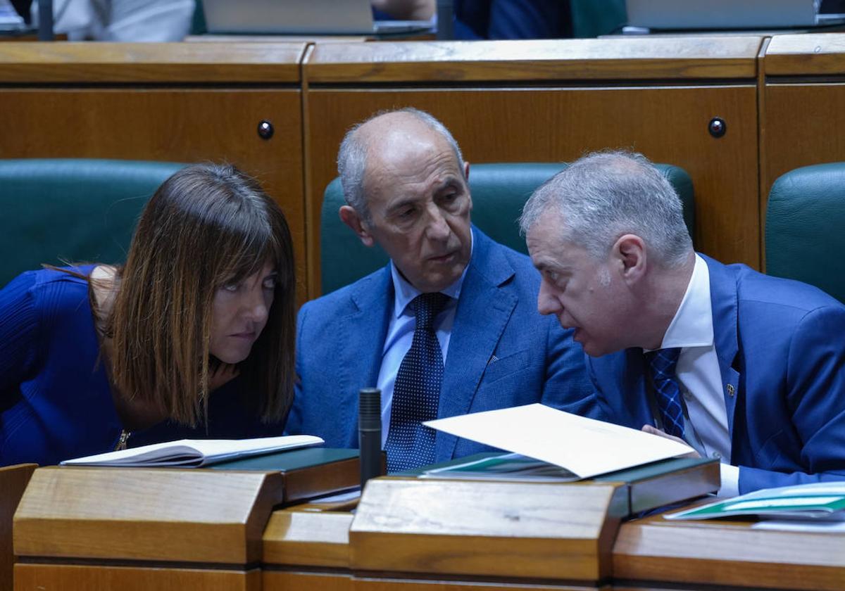 Idoia Mendia, Josu Erkoreka e Iñigo Urkullu conversan durante un pleno parlamentario.