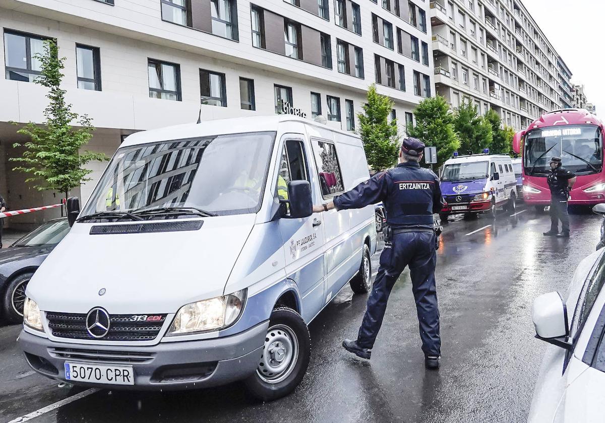 Un ertzaina controla el furgón funerario en las inmediaciones del apartahotel donde se produjo el crimen de Maialen.