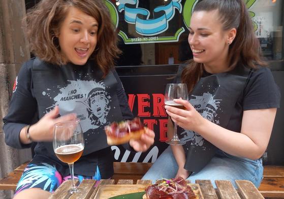 Dos jóvenes toman el aperitivo con babero en Dando la Brasa.