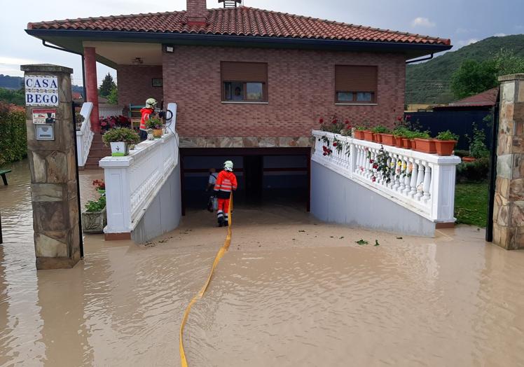 Imagen principal - En Puentelarra el agua ha entrado en algunas viviendas.