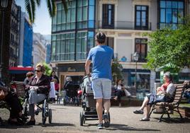 Un padre pasea con su hijo por Bilbao