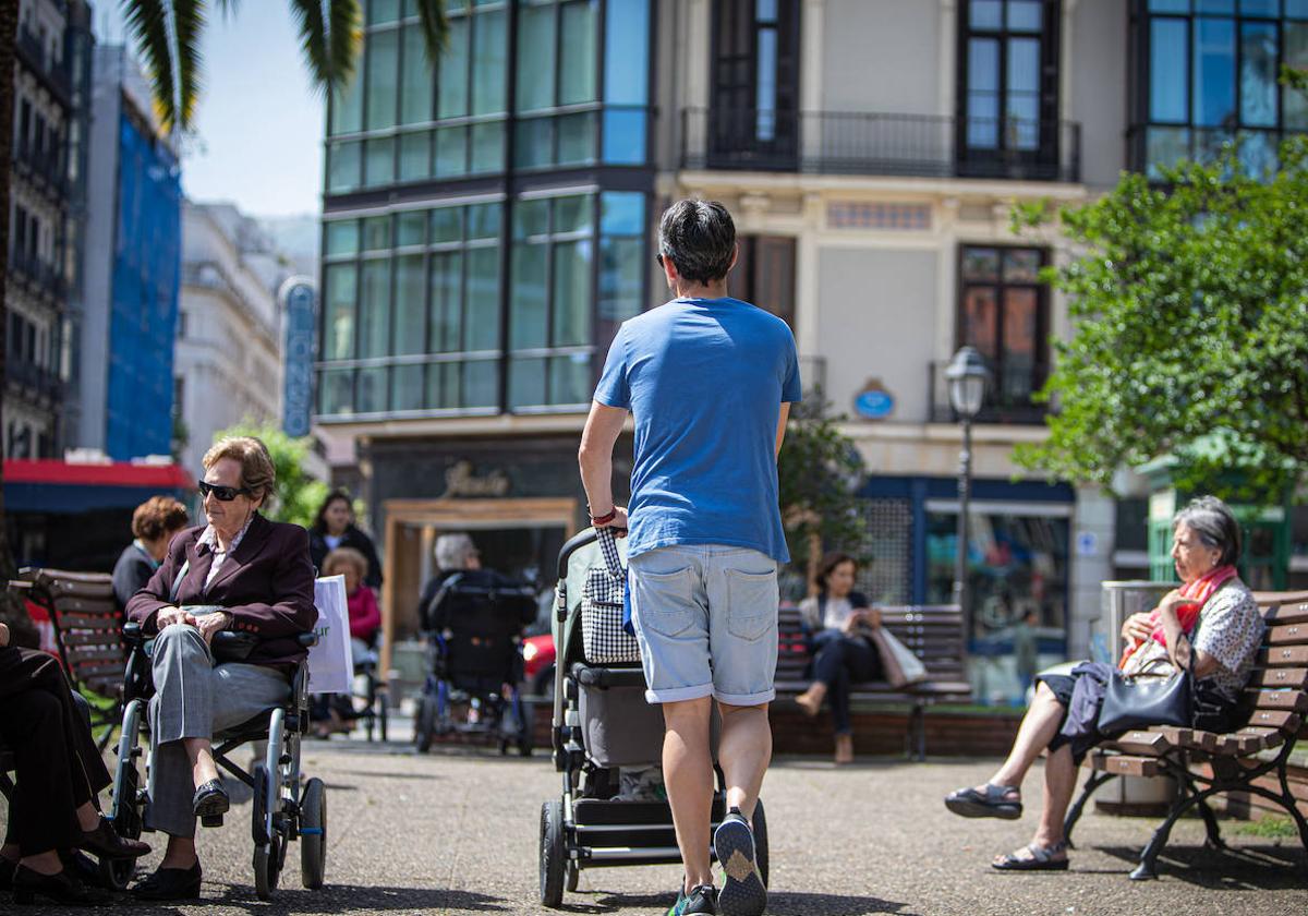 Un padre pasea con su hijo por Bilbao