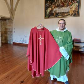 El padre Luis Martín muestra muestra y viste dos de las casullas que ha confeccionado en su taller.