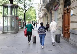 Turistas con sus maletas por la Gran Vía de Bilbao