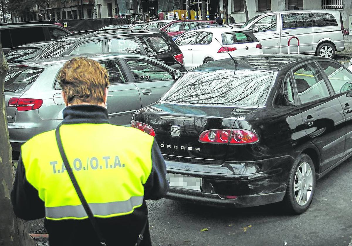 Un trabajador de la OTA verifica la matrícula de un vehículo para saber si ha abonado el tiempo correspondiente o lo ha superado.