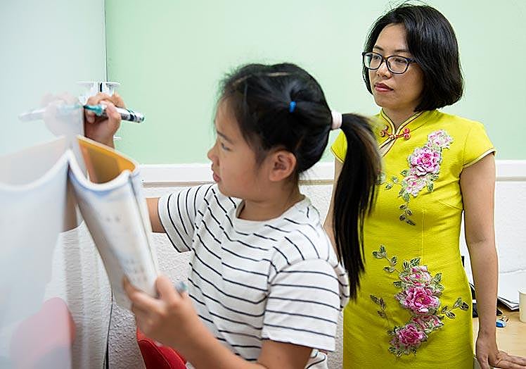 Qin Yingying enseña a escribir en chino a la pequeña Hu Chenxi