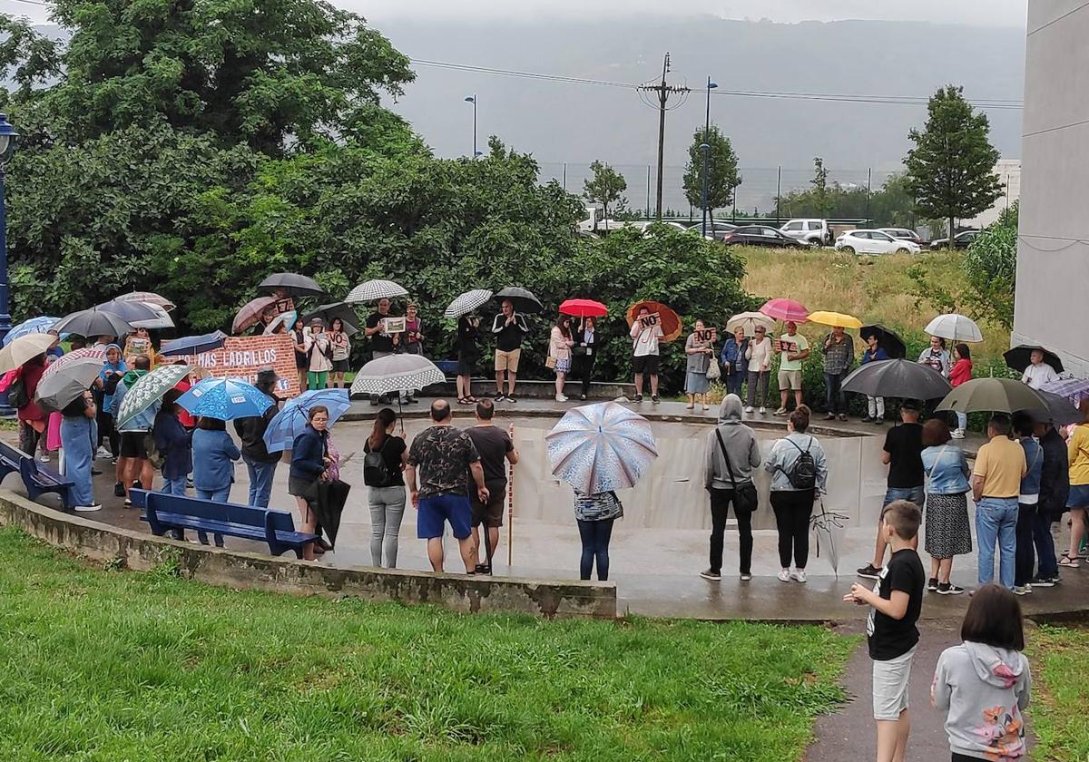 Los vecinos se tuvieron que refugiar bajo los paraguas debido a la lluvia.