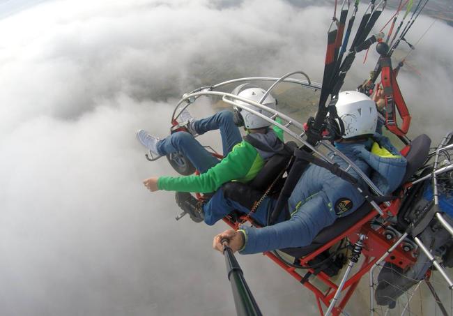 Un joven disfruta de la experiencia de volar en un paratrike dirigido por un experimentado piloto.