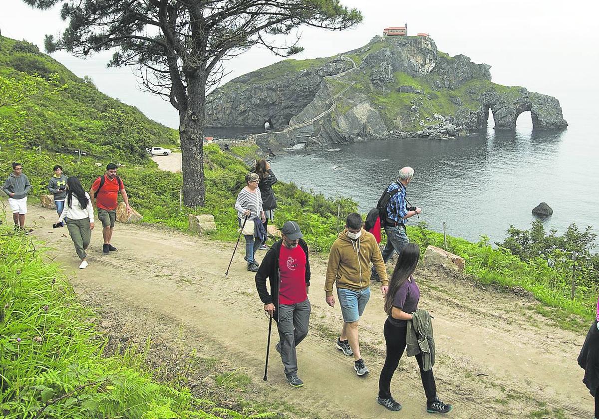 Un grupo de excursionistas disfruta de un paseo por el entorno de San Juan de Gaztelugatxe, próximo al cabo Matxitxako.