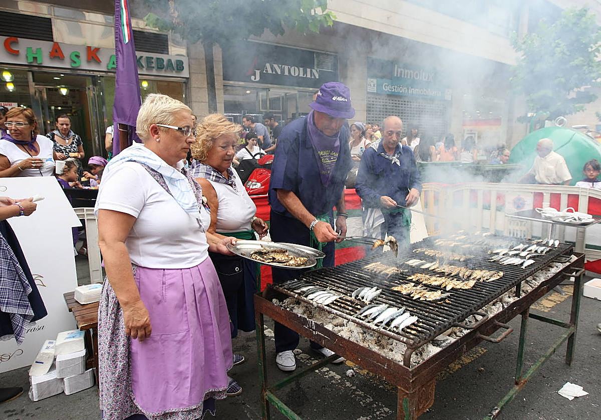 Miles de personas abarrotan las calles Itsasalde y Juan XXIII en la Gran Sardinada para degustar el preciado pescado de Santurtzi.