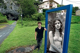 Javier Bejarano, apoyado en la imagen de su sobrina Ágata, fotografiada en el concejo asturiano de Villaviciosa. El panel se ha ubicado delante de Aldecueva.