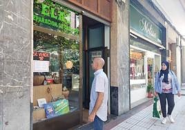 Un vecino lee el cartel de 'Se vende' que forma parte de la campaña de comercio impulsada en Amorebieta