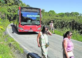 Varios vecinos transitan por la carretera al paso del Bilbobus.