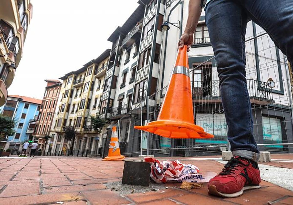 Un joven levanta uno de los conos que oculta uno de los tres bolardos que fueron cortados.