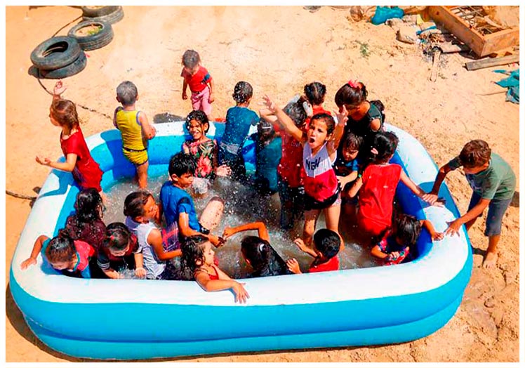 Niños y niñas juegan en una piscina hinchable en la Franja de Gaza.