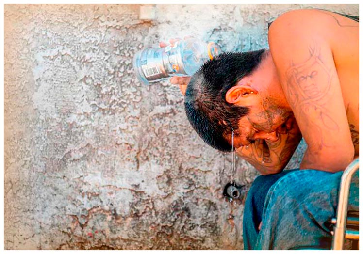 Un joven de Phoenix, Arizona, prefiere emplear su botella de agua para mojarse la cabeza en lugar de beberla.