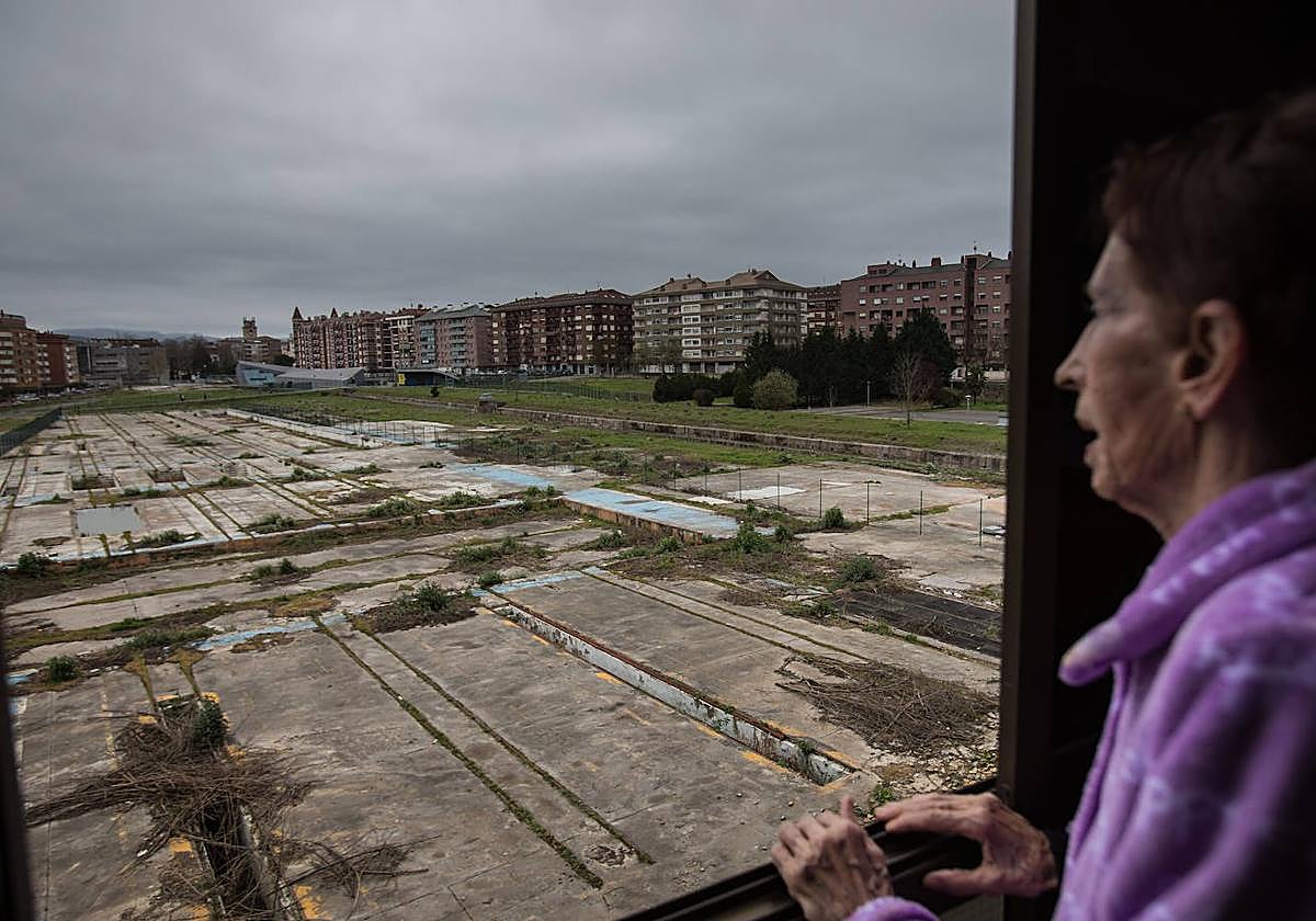 Una mujer observa desde la ventana de su casa los antiguos terrenos del tren en Durango