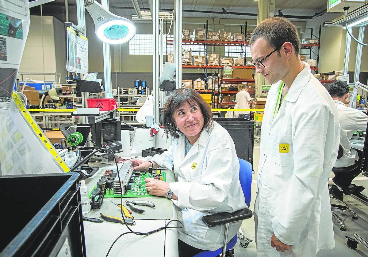 Begoña Miranda supervisa placas electrónicas en Sestao y Aleksei Berezin trabaja en la limpieza de una residencia de Balmaseda.